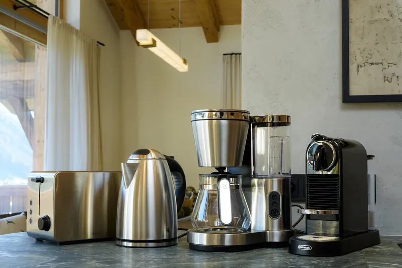 Toaster, Wasserkocher, Filterkaffeemaschine und Kapsel-Kaffeemaschine auf der Küchenarbeitsplatte